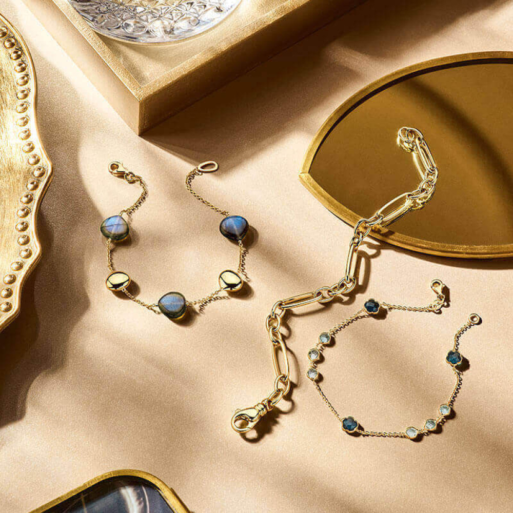 goudkleurige-schakelarmband-met-blauwe-topaasstenen