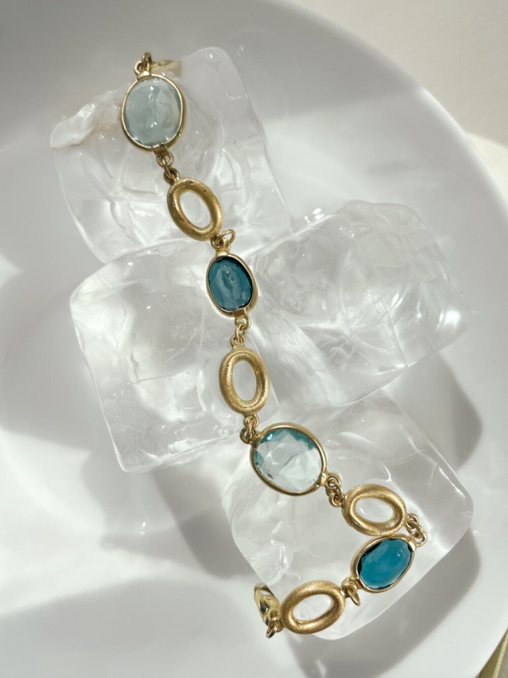 gouden-armband-met-matte-ovalen-en-blauwe-topaas-stenen-lengte-19-cm