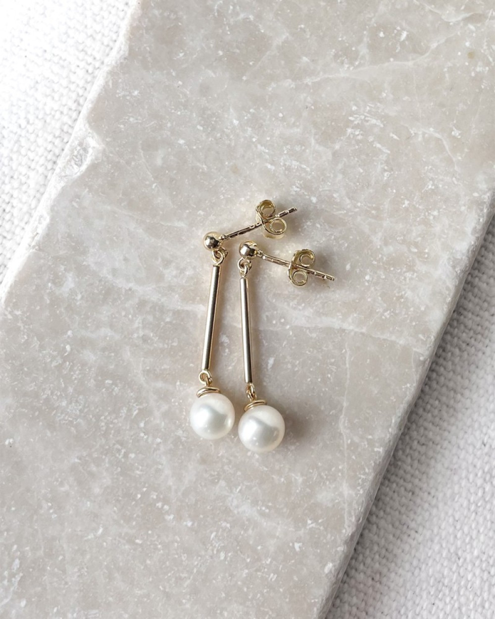 strakke-gouden-oorhangers-met-witte-zoetwaterparels-hoogte-29-mm